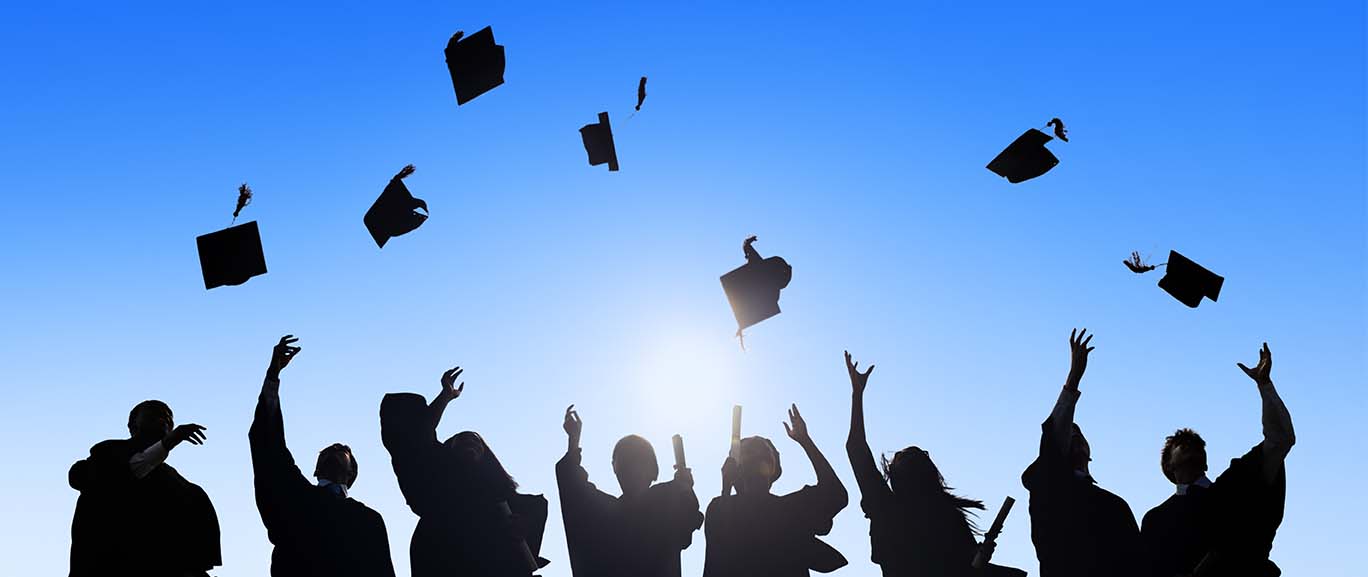 Students throwing caps into the air at graduation